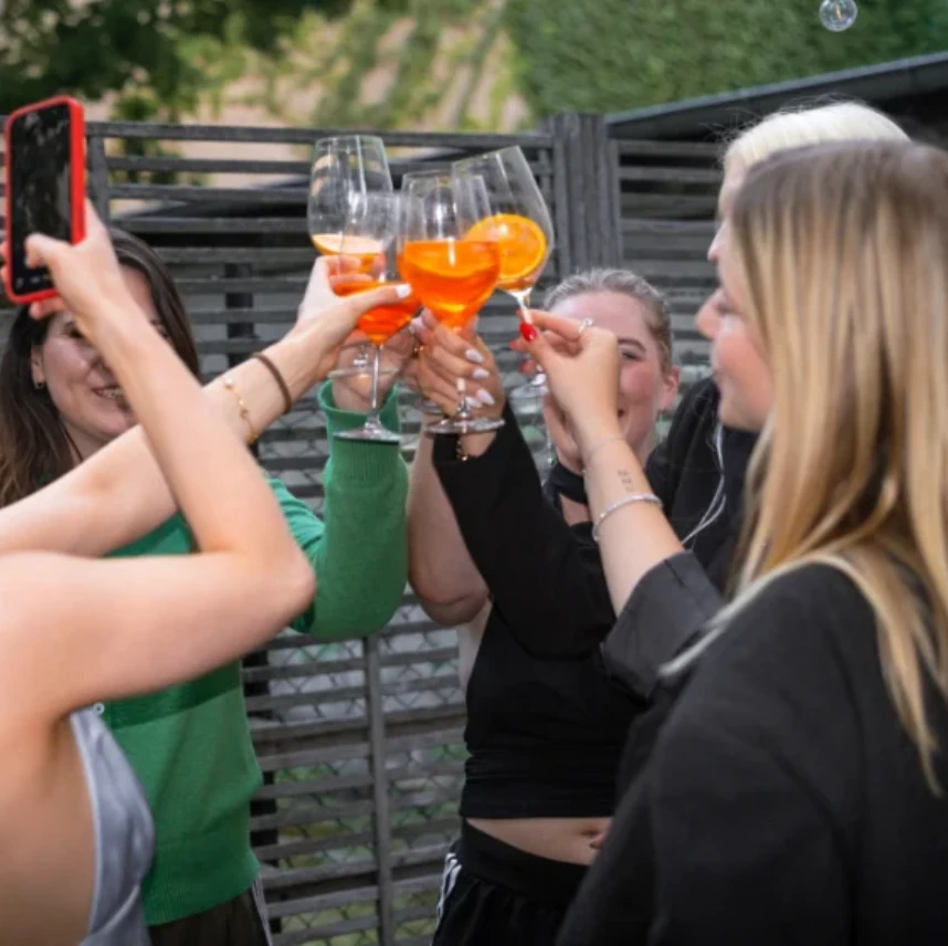 Mitglieder der Community stoßen bei einem Stammtisch miteinander an
